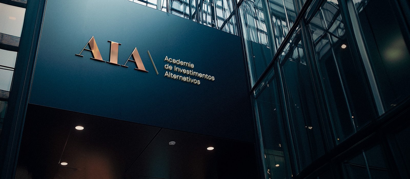 Logotipo da AIA em letras metálicas na fachada de um edifício corporativo