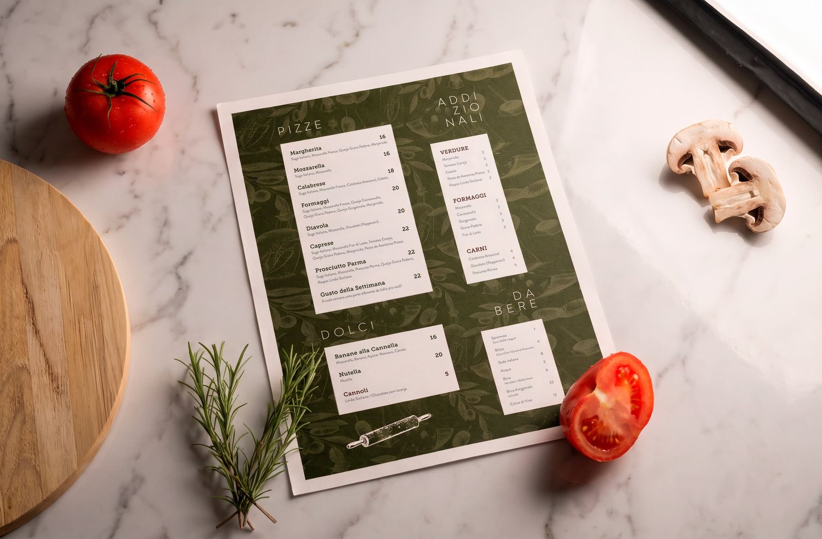 Cardápio da CIAO em verde sobre bancada de mármore com tomates e ervas